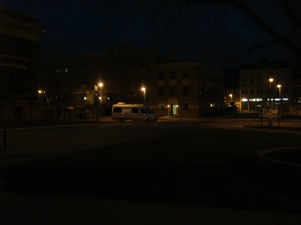 Council Bluffs after dark: the van, and the squirrel cage jail's sign. Closed for the season.