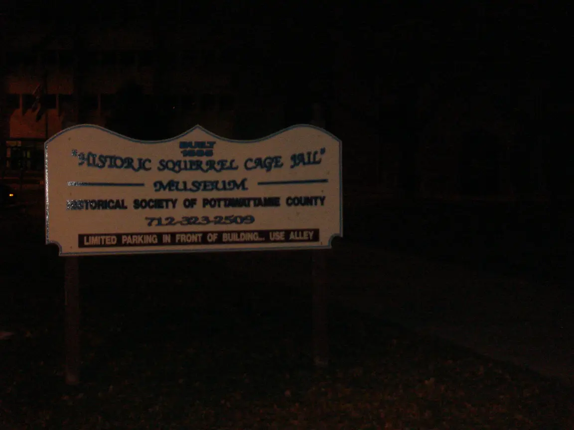 Council Bluffs after dark: the van, and the squirrel cage jail's sign. Closed for the season.