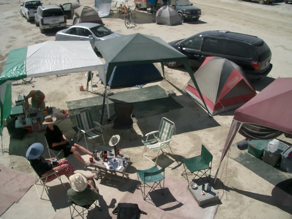 2004: three canopies around a carpeted common area, the kitchen under one and storage bins under another