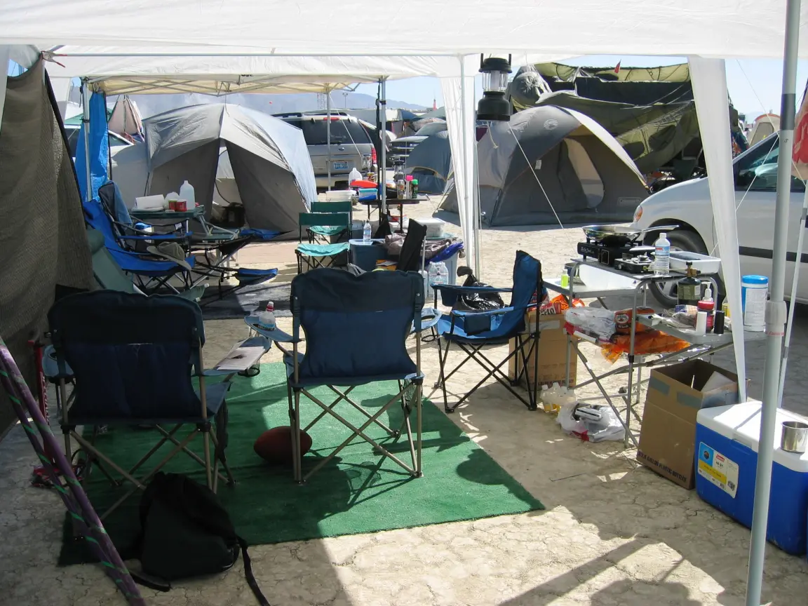 2005: joined canopies over turf, with a camp kitchen, two-burner stove, and cooler