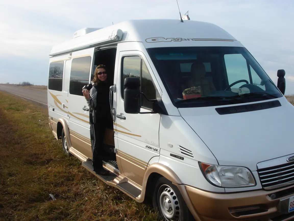 Jess standing in the van's side door holding her camera